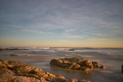 Brown rock formation on the sea during the day
